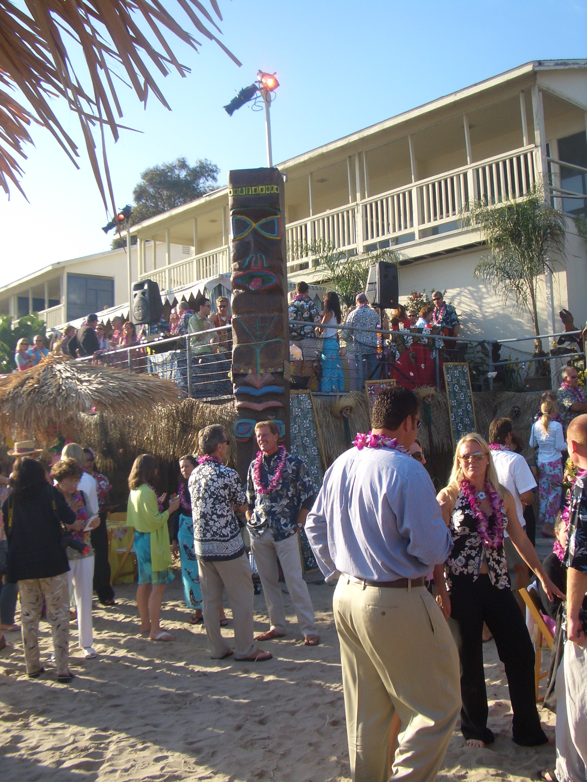 Large convention luau event with guests, thatched umbrellas, and tropical décor in Las Vegas