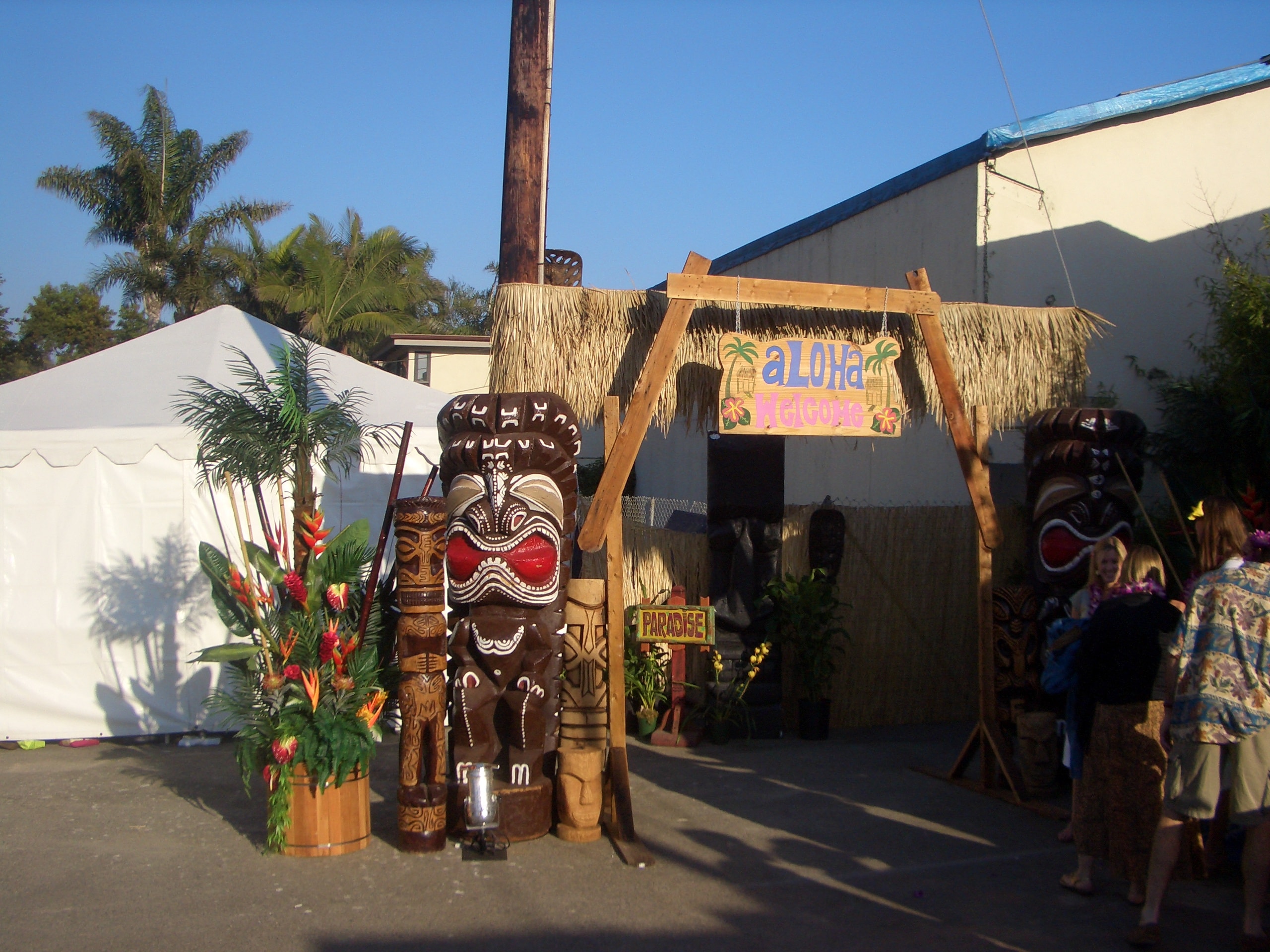 Aloha Welcome entrance arch with thatched roof, palm trees, and tropical flowers at a Henderson, NV event
