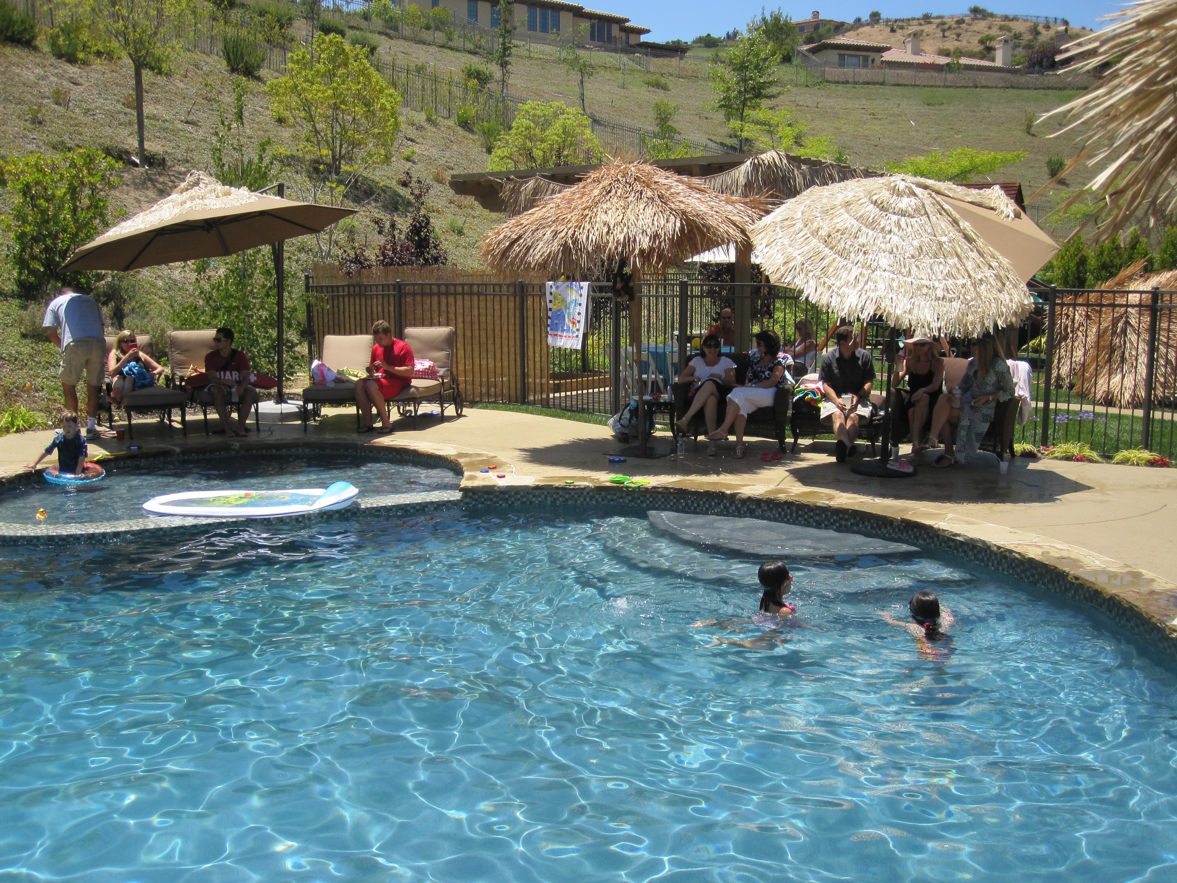 Backyard luau setup with tropical tiki decorations and guests celebrating in Las Vegas, NV