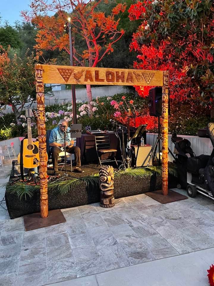Traditional Polynesian outrigger canoe prop with carved paddle shields and tiki stool at a Las Vegas luau