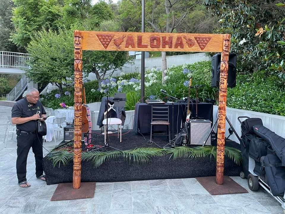 Aloha stage arch with carved tiki pillars and sound equipment set up for a corporate luau in Las Vegas, NV